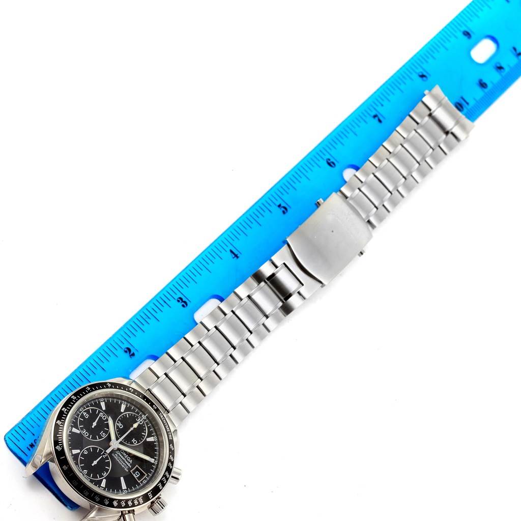The Omega Speedmaster 3210.50.00 Men
s Stainless Steel Black Dial 3210.50.00 Men
s Stainless Steel Black Dial watch is shown horizontally with its full bracelet and clasp laid along a blue ruler.