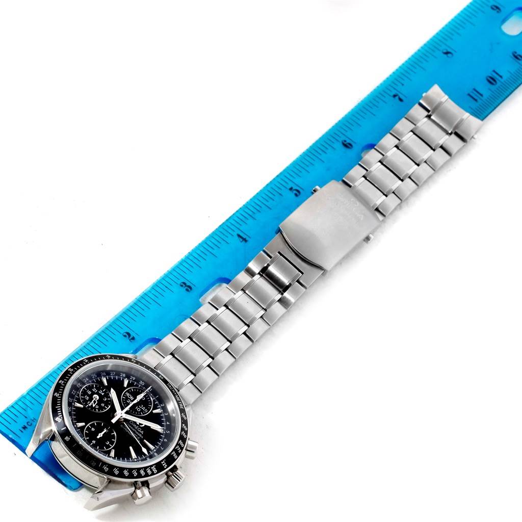 The image shows the Omega Speedmaster 3220.50.00 Men
s Stainless Steel Black Dial 3220.50.00 Men
s Stainless Steel Black Dial watch face and stainless steel bracelet, laid next to a blue ruler for measurement.