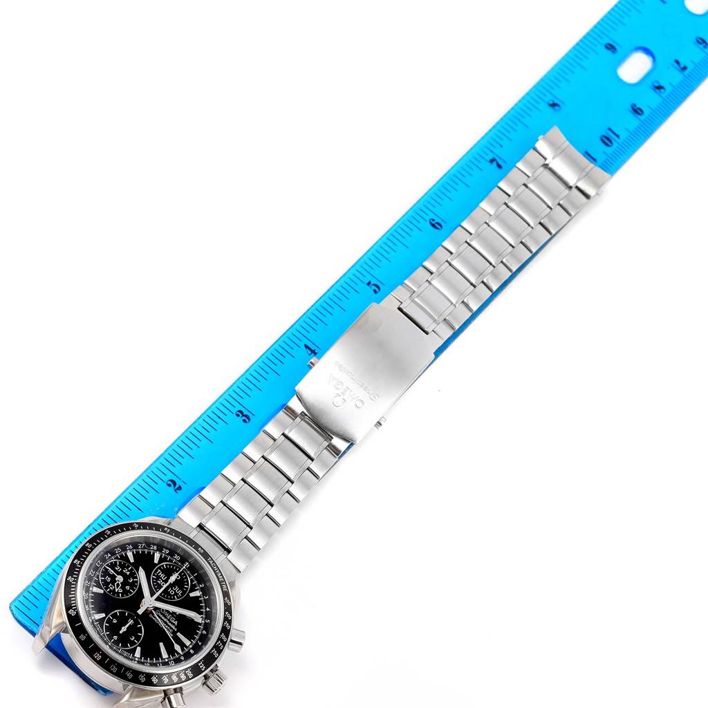 The image shows an Omega Speedmaster 3220.50.00 Men
s Stainless Steel Black Dial 3220.50.00 Men
s Stainless Steel Black Dial watch lying flat with the face and metal bracelet fully visible next to a blue ruler.