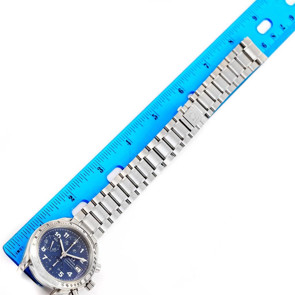 The image shows the Omega Speedmaster 3513.82.00 Men
s Stainless Steel Blue Dial 3513.82.00 Men
s Stainless Steel Blue Dial watch laid flat, with a focus on the entire watch and its metal bracelet, measured against a blue ruler.