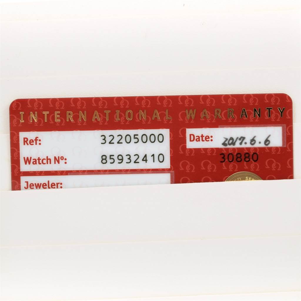 The image shows an Omega Speedmaster 3220.50.00 Men
s Stainless Steel Black Dial 3220.50.00 Men
s Stainless Steel Black Dial
s international warranty card partially inserted in a white holder, displaying the reference and watch number.