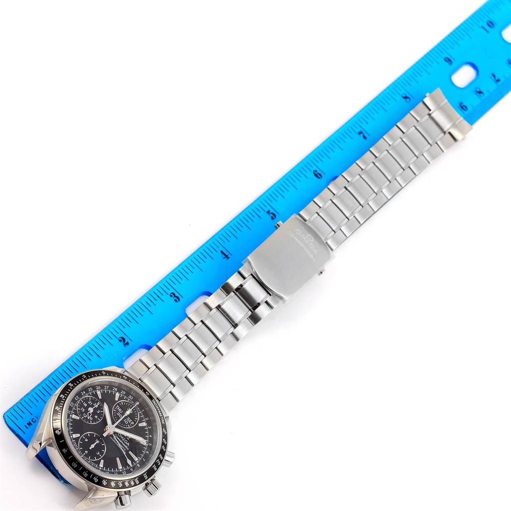 The image shows an Omega Speedmaster 3220.50.00 Men
s Stainless Steel Black Dial 3220.50.00 Men
s Stainless Steel Black Dial watch laid flat with a metal bracelet and a blue ruler for scale.