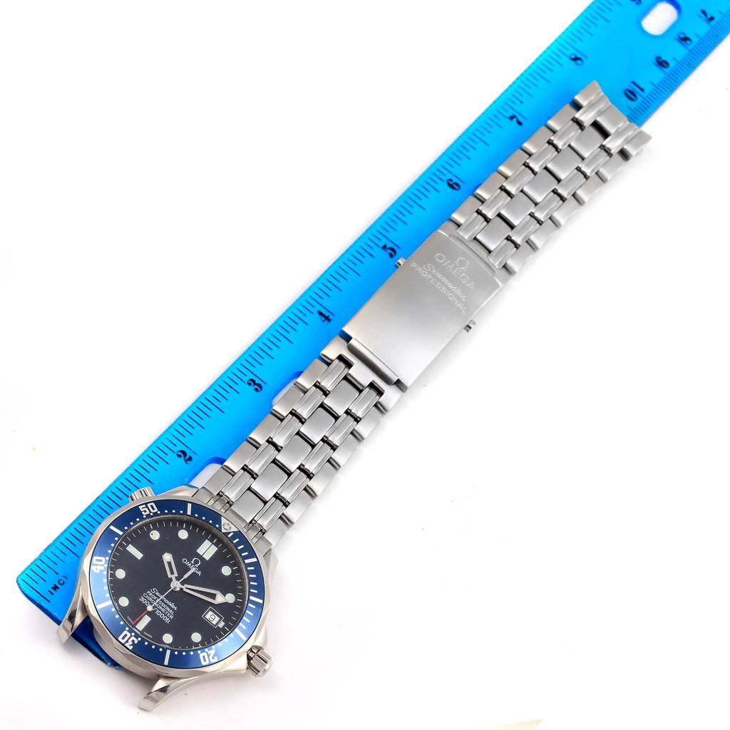 The image shows an Omega Speedmaster 2531.80.00 Men
s Stainless Steel Blue Dial 2531.80.00 Men
s Stainless Steel Blue Dial watch laid flat next to a blue ruler, displaying the watch
s face, bezel, and stainless steel bracelet.