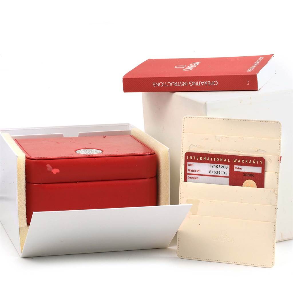 The image shows the packaging, warranty card, and operating instructions of the Omega Speedmaster 3210.52.00 Men
s Stainless Steel Black Dial 3210.52.00 Men
s Stainless Steel Black Dial watch.