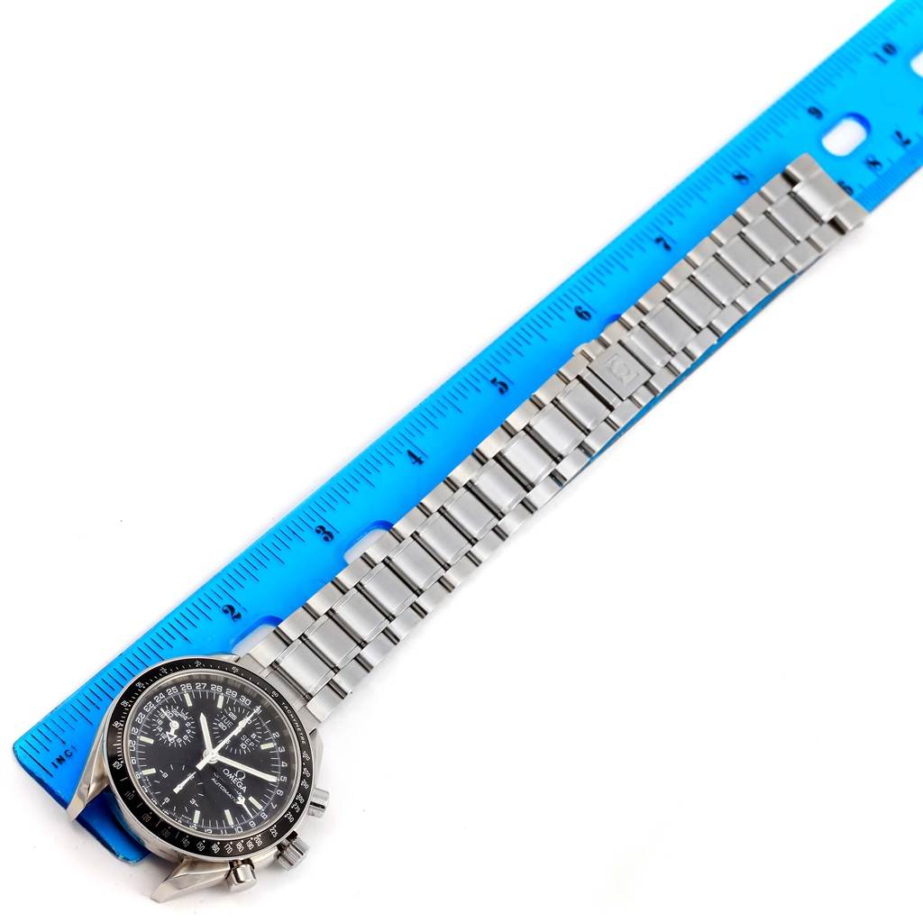 The image shows an Omega Speedmaster 3520.50.00 Men
s Stainless Steel Black Dial 3520.50.00 Men
s Stainless Steel Black Dial watch with a metal bracelet aligned next to a blue ruler for measurement.