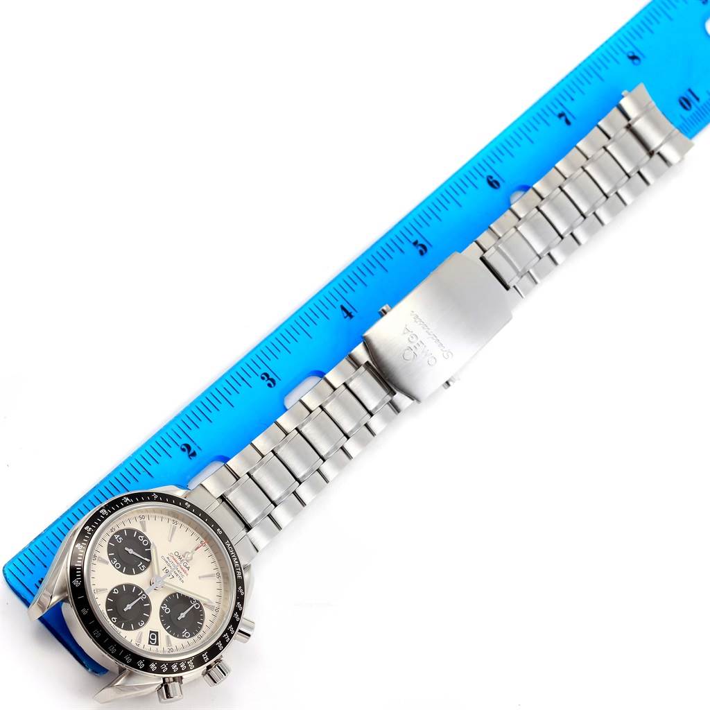 The Omega Speedmaster 323.30.40.40.02.001 Men's Stainless Steel White Dial 323.30.40.40.02.001 Men's Stainless Steel White Dial watch is shown from a top-down angle with its dial, bezel, and bracelet extended next to a ruler.