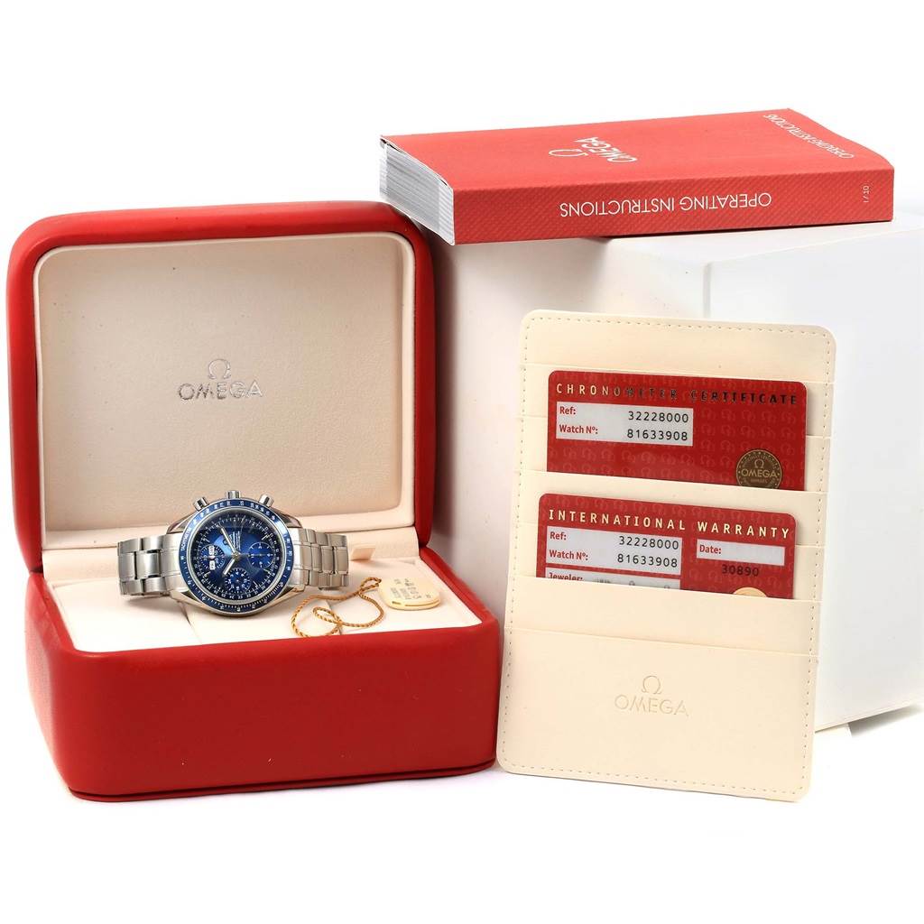 The image shows an Omega Speedmaster 3222.80.00 Men
s Stainless Steel Blue Dial 3222.80.00 Men
s Stainless Steel Blue Dial watch in its box, along with warranty cards and an operating instructions booklet.