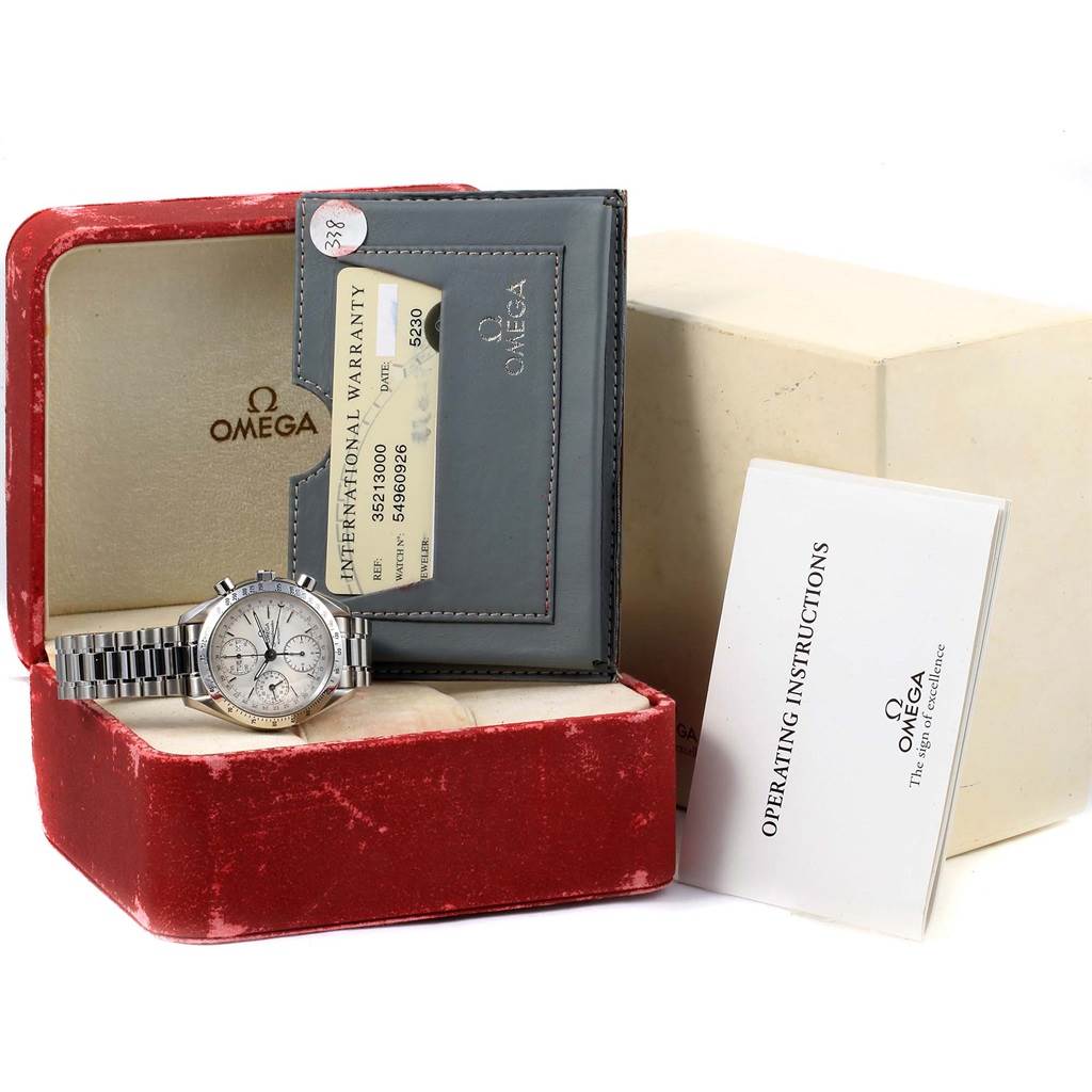 The Omega Speedmaster 3521.30.00 Men
s Stainless Steel Silver Dial 3521.30.00 Men
s Stainless Steel Silver Dial watch is displayed in an open red case, accompanied by its warranty card and operating instructions.