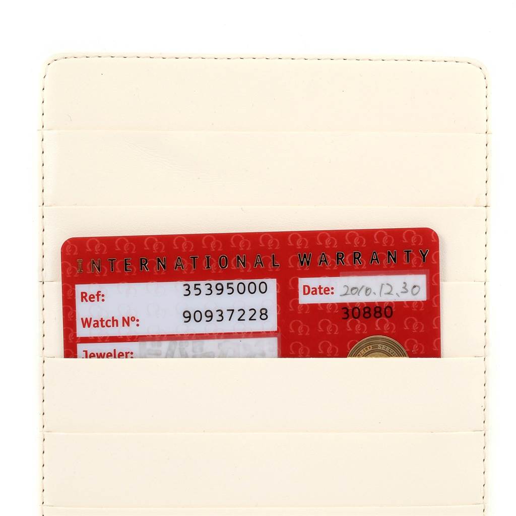 The image shows the international warranty card for an Omega Speedmaster 3539.50.00 Men
s Stainless Steel Black Dial 3539.50.00 Men
s Stainless Steel Black Dial watch, placed in a cream-colored cardholder.