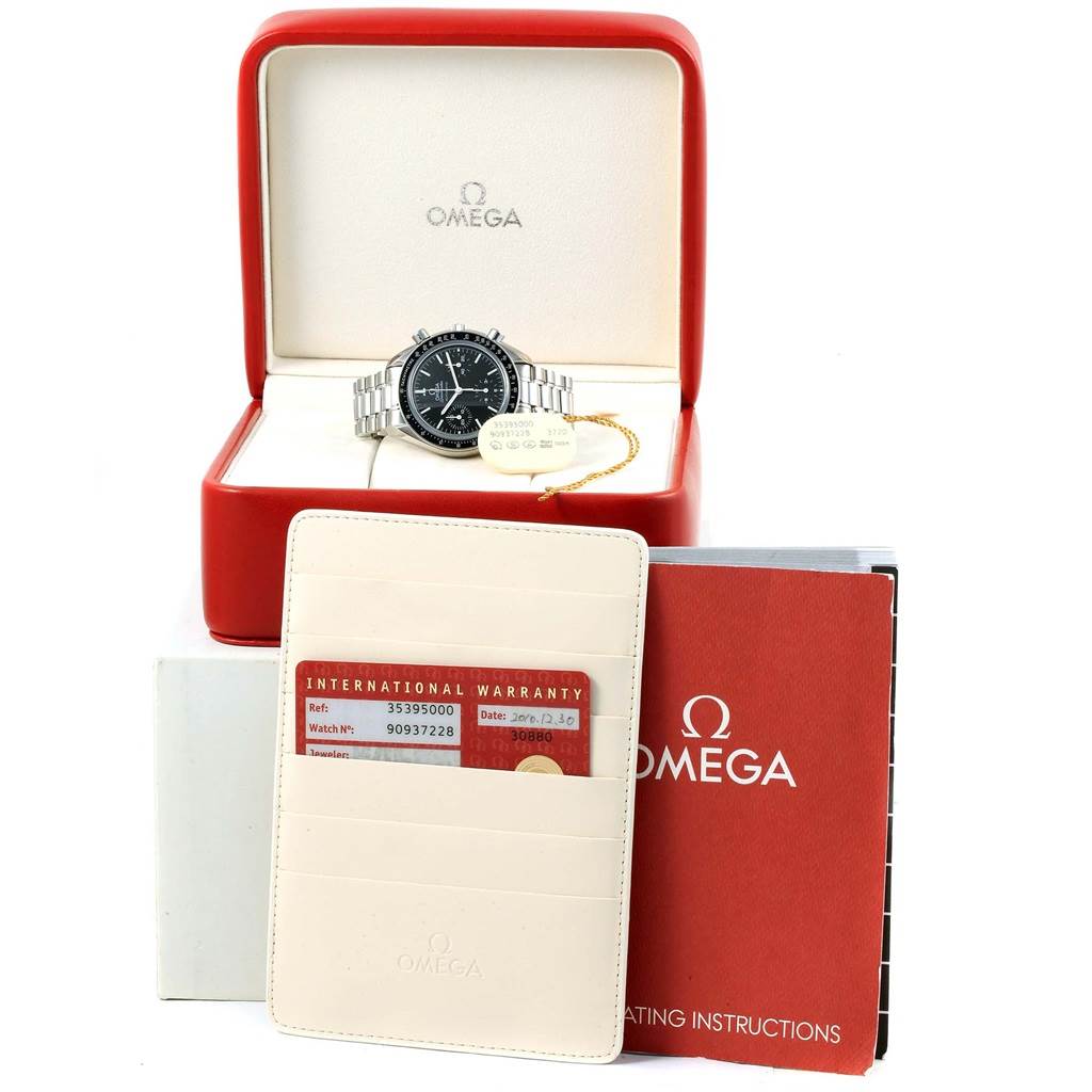 The Omega Speedmaster 3539.50.00 Men
s Stainless Steel Black Dial 3539.50.00 Men
s Stainless Steel Black Dial watch is shown in its open box, with warranty cards, a tag, and an instruction manual in the foreground.