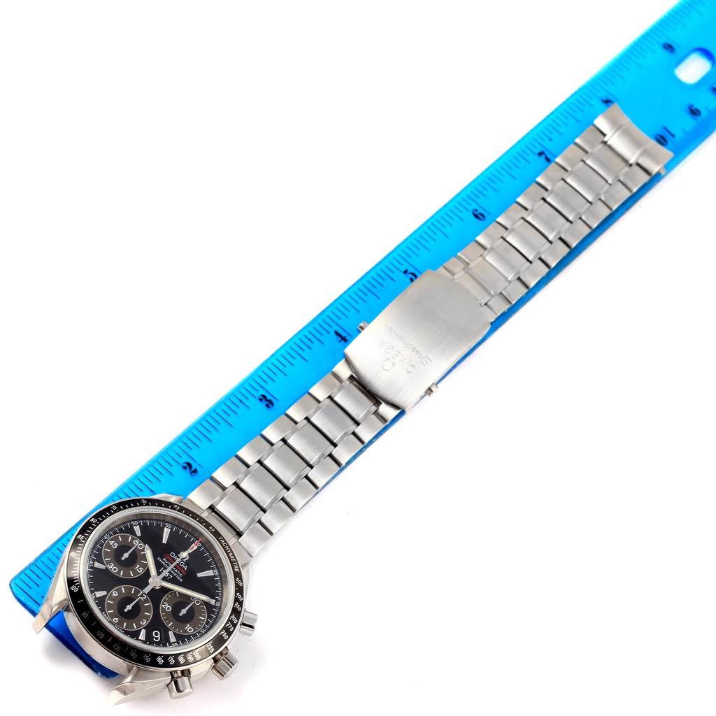 The image shows an Omega Speedmaster 323.30.40.40.01.001 Men's Stainless Steel Black Dial 323.30.40.40.01.001 Men's Stainless Steel Black Dial watch, angled flat with the face and the entirety of its metal bracelet visible, next to a ruler.
