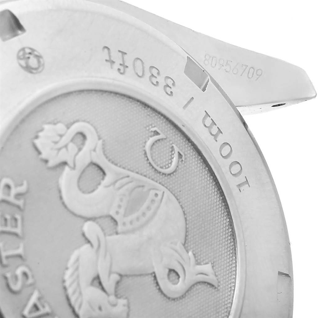 The image shows the stainless steel back casing of an Omega Speedmaster 323.30.40.40.01.001 Men's Stainless Steel Black Dial 323.30.40.40.01.001 Men's Stainless Steel Black Dial watch, including an engraved emblem and some serial numbers.