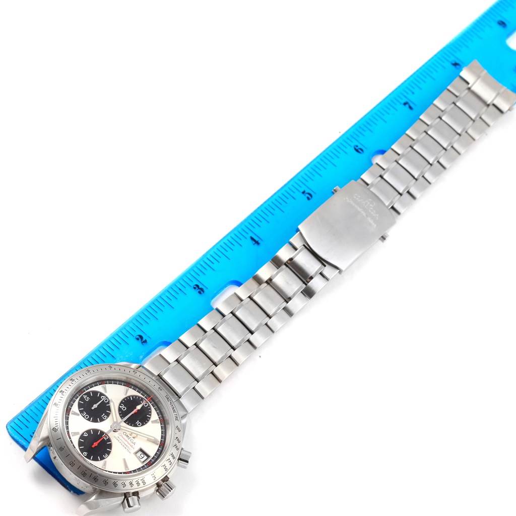 The image shows an Omega Speedmaster 3211.31.00 Men
s Stainless Steel Silver Dial 3211.31.00 Men
s Stainless Steel Silver Dial watch resting next to a blue ruler, highlighting the length of its stainless steel band.