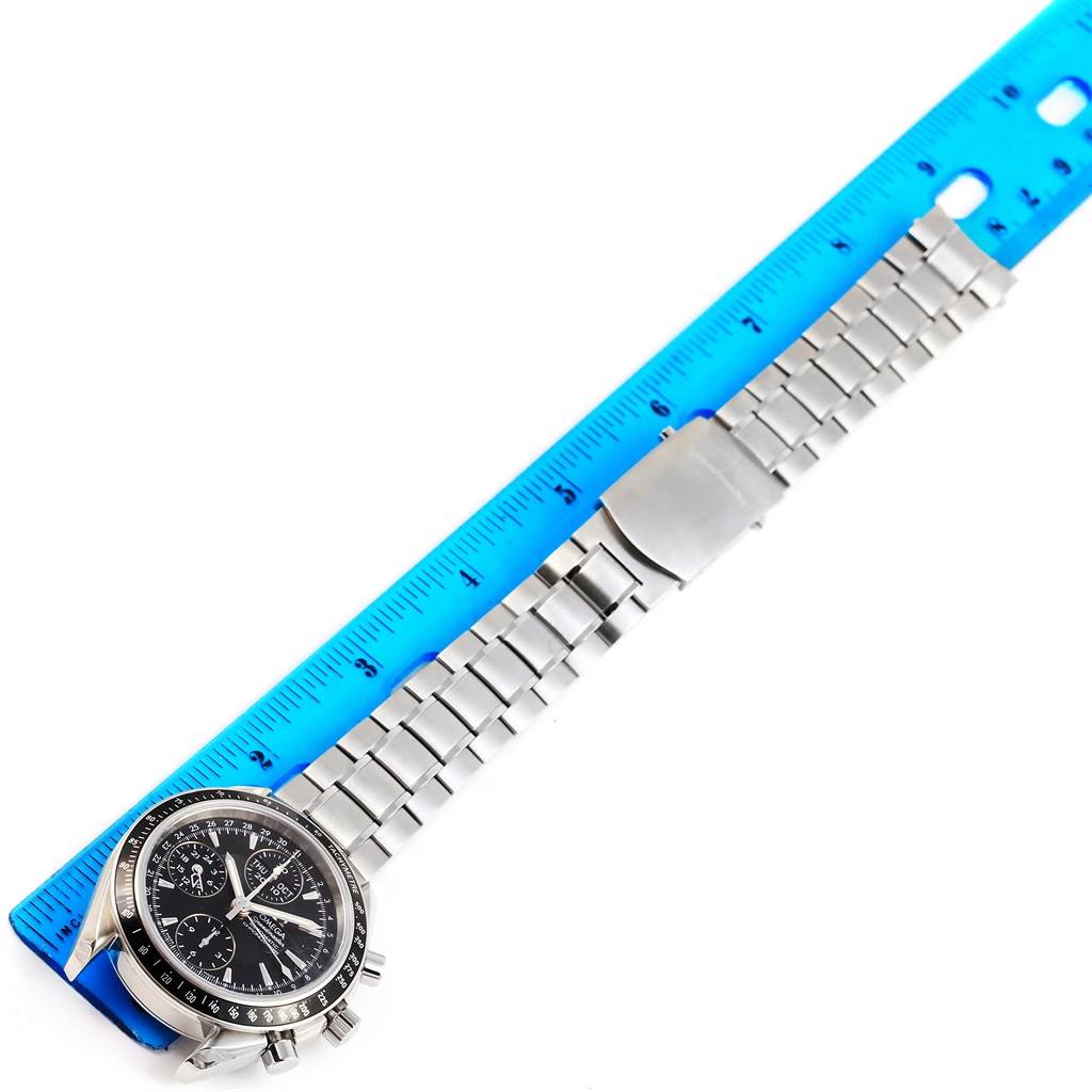 The image shows an Omega Speedmaster 3220.50.00 Men
s Stainless Steel Black Dial 3220.50.00 Men
s Stainless Steel Black Dial watch placed next to a blue ruler, displaying the face and metal bracelet from an overhead angle.