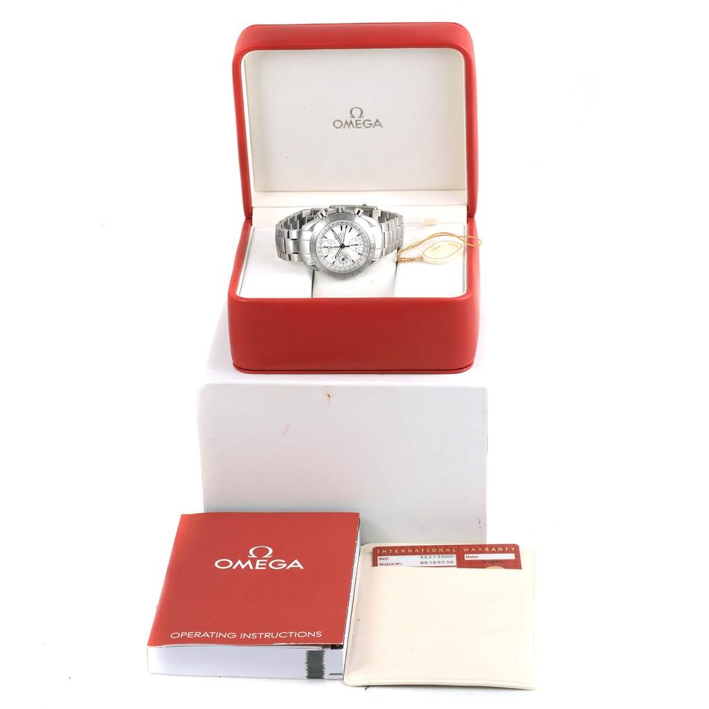 The image shows an Omega Speedmaster 3221.30.00 Men's Stainless Steel Silver Dial 3221.30.00 Men's Stainless Steel Silver Dial watch in its box, accompanied by an operating instruction manual and an international warranty card.