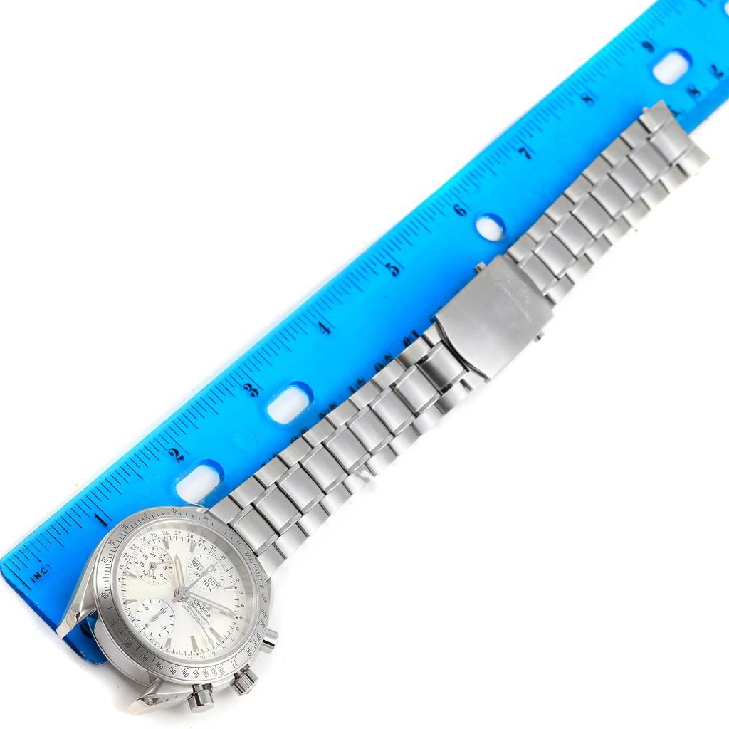 The image shows an Omega Speedmaster 3221.30.00 Men's Stainless Steel Silver Dial 3221.30.00 Men's Stainless Steel Silver Dial watch lying flat next to a ruler, displaying both the watch face and the metal bracelet.