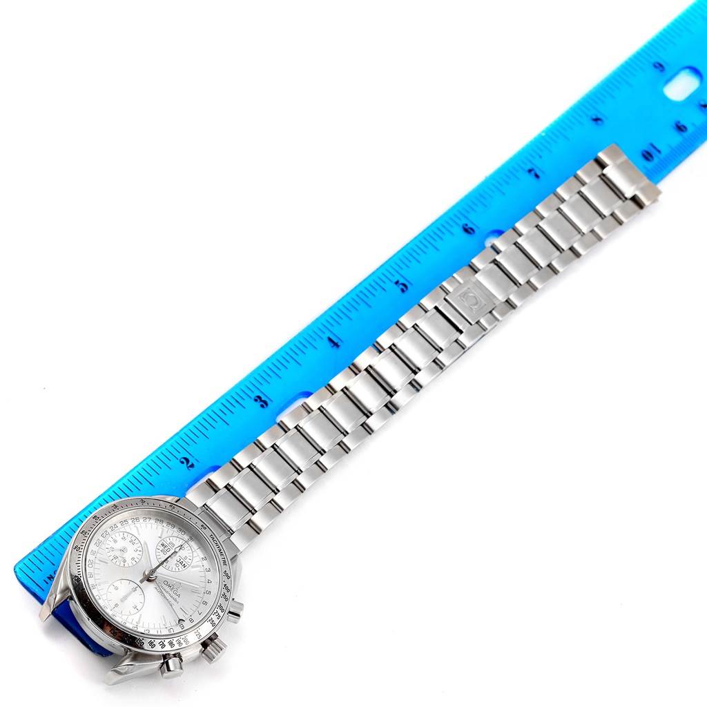 The image shows an Omega Speedmaster 3523.30.00 Men
s Stainless Steel Silver Dial 3523.30.00 Men
s Stainless Steel Silver Dial watch laid flat with its stainless steel bracelet next to a blue ruler for scale.
