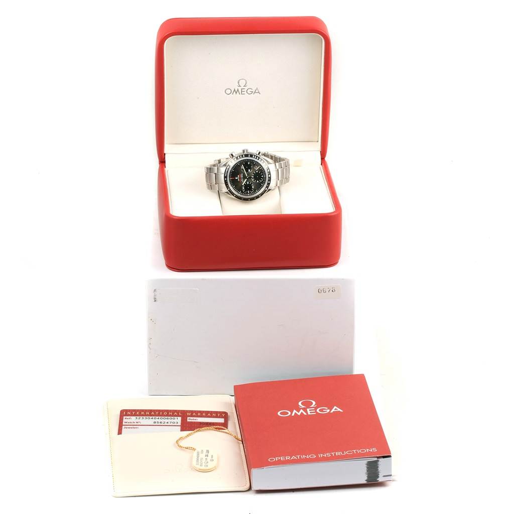 The image shows an Omega Speedmaster 323.30.40.40.06.001 Men's Stainless Steel Grey Dial 323.30.40.40.06.001 Men's Stainless Steel Grey Dial watch in its red box, accompanied by an international warranty card and operating instructions.