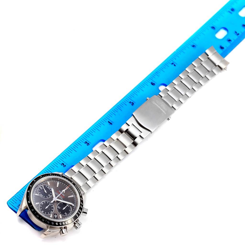 The image shows the Omega Speedmaster 323.30.40.40.06.001 Men's Stainless Steel Grey Dial 323.30.40.40.06.001 Men's Stainless Steel Grey Dial watch laid flat, with its dial and metal bracelet visible alongside a ruler for scale.