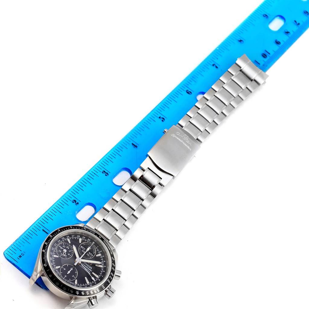 This image shows a top view of an Omega Speedmaster 3220.50.00 Men
s Stainless Steel Black Dial 3220.50.00 Men
s Stainless Steel Black Dial with a metal bracelet next to a blue ruler for scale.