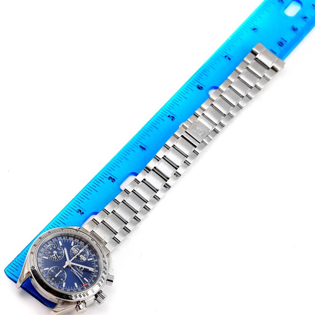 The Omega Speedmaster 3523.80.00 Men
s Stainless Steel Blue Dial 3523.80.00 Men
s Stainless Steel Blue Dial watch is shown from a top-down angle next to a ruler, displaying its face and metal bracelet.