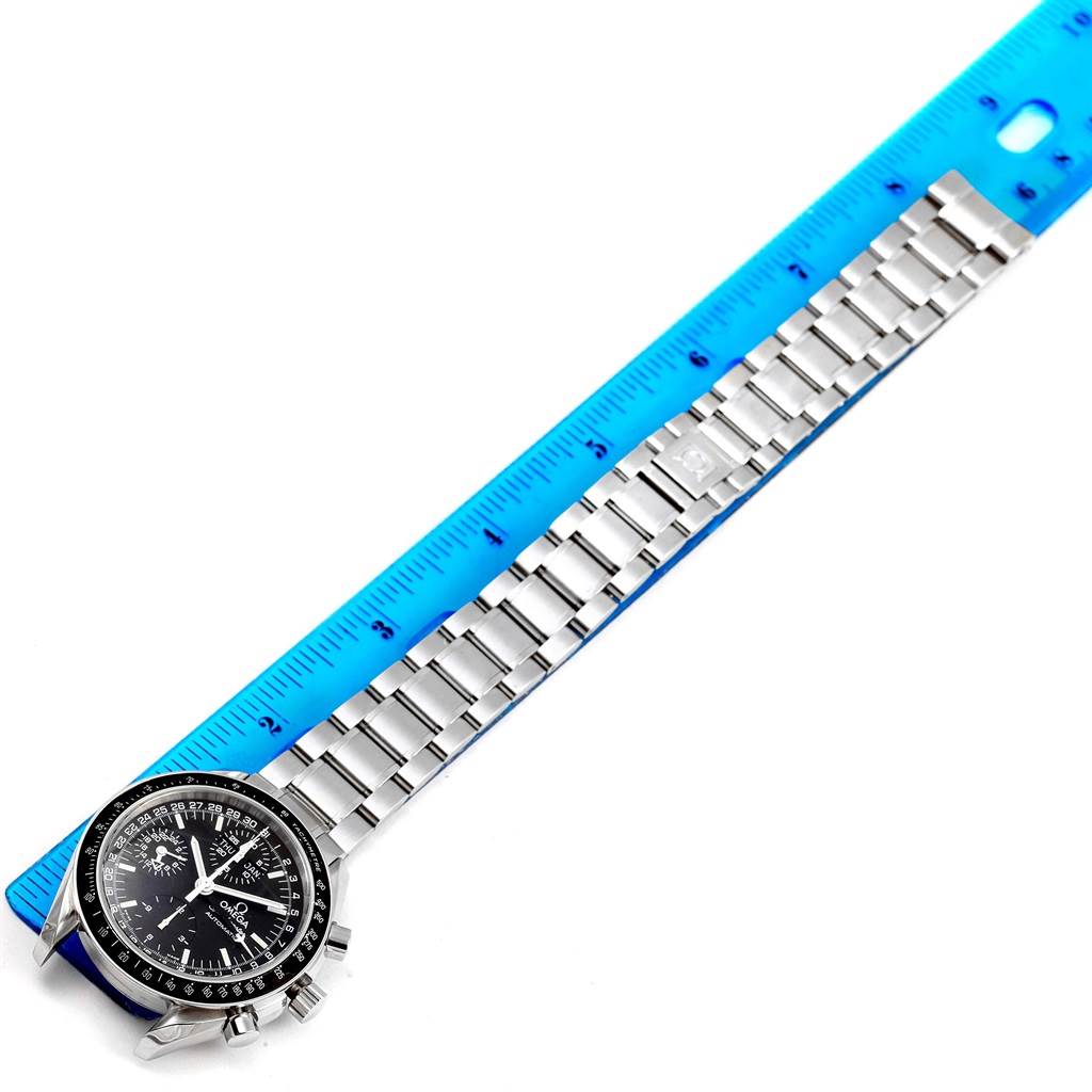 The image shows an Omega Speedmaster 3520.50.00 Men
s Stainless Steel Black Dial 3520.50.00 Men
s Stainless Steel Black Dial watch laid flat with its metal bracelet alongside a blue ruler.