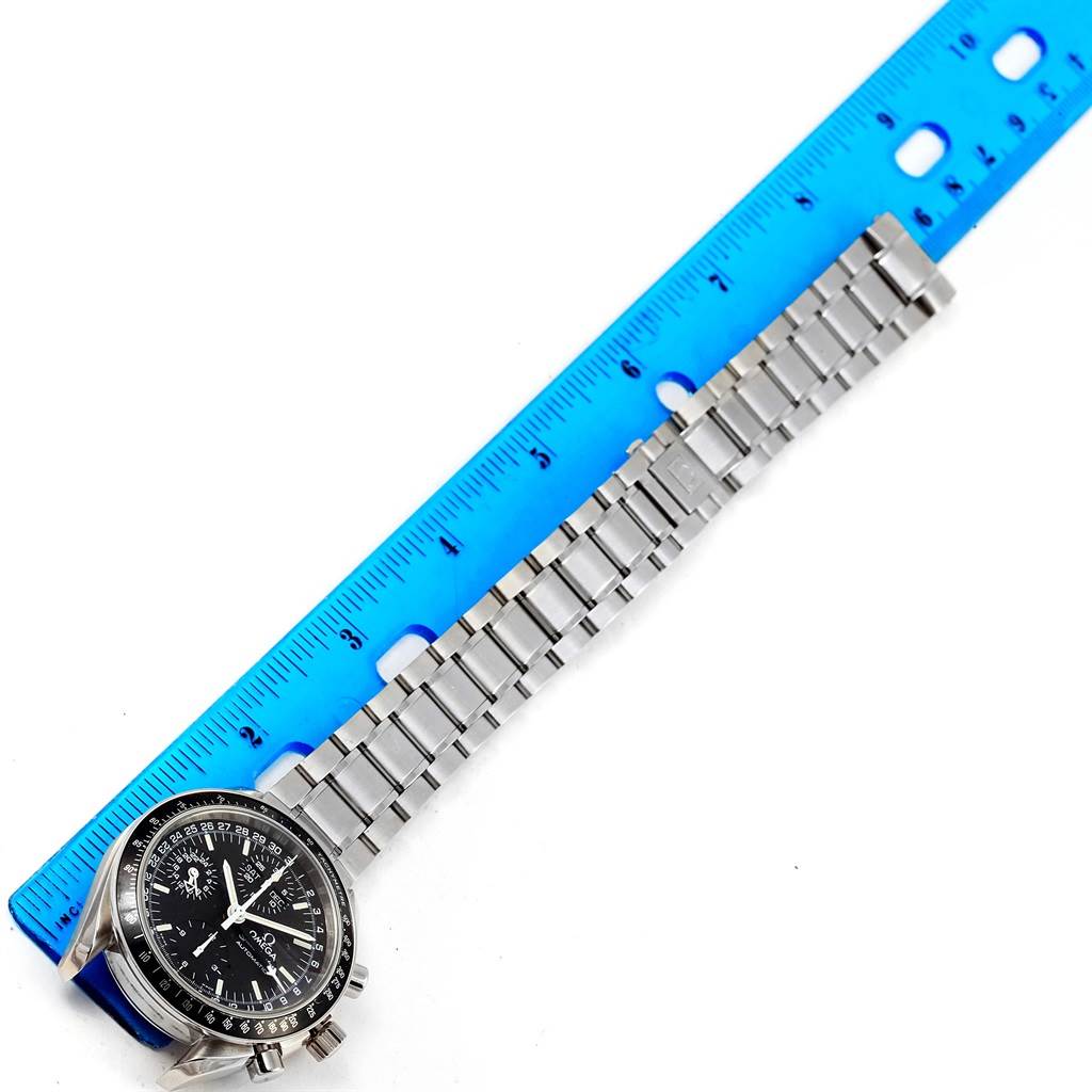 The image shows an Omega Speedmaster 3520.50.00 Men
s Stainless Steel Black Dial 3520.50.00 Men
s Stainless Steel Black Dial watch with a stainless steel bracelet, measured against a blue ruler.