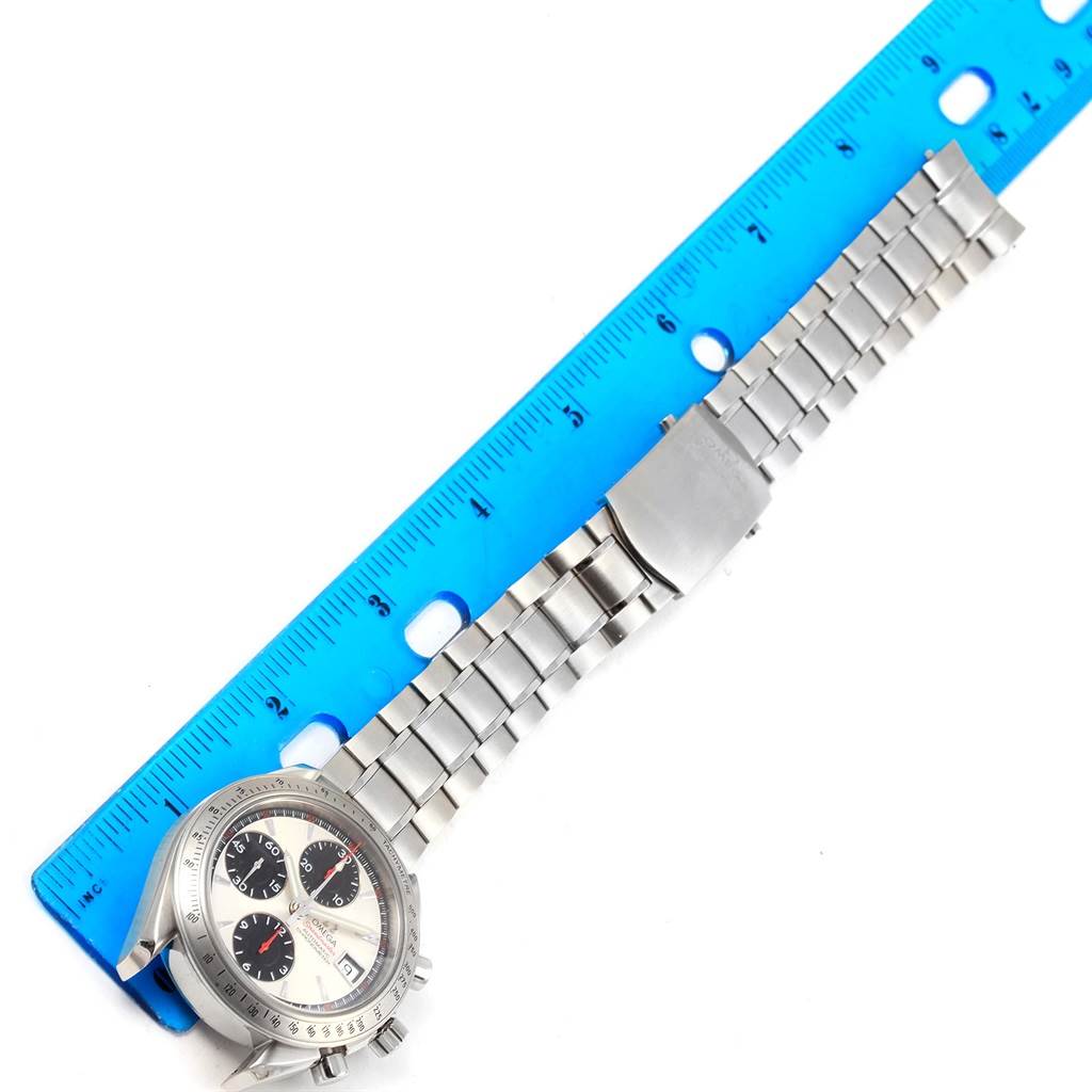 The image shows an Omega Speedmaster 3211.31.00 Men
s Stainless Steel Silver Dial 3211.31.00 Men
s Stainless Steel Silver Dial watch with a metal bracelet, placed alongside a blue ruler for measurement.