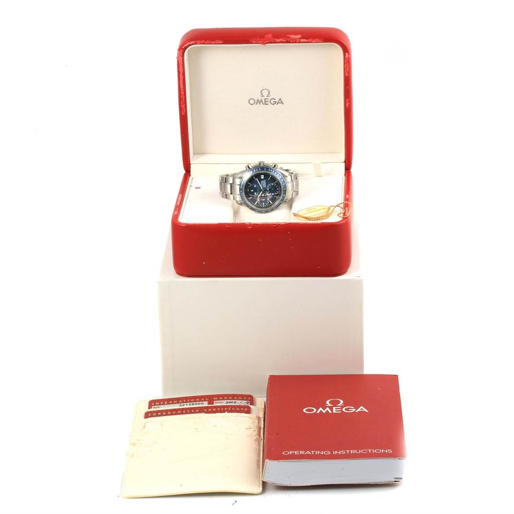 The Omega Speedmaster 3212.80.00 Men
s Stainless Steel Blue Dial 3212.80.00 Men
s Stainless Steel Blue Dial watch is displayed in an open red case, with booklets and warranty cards shown in front.