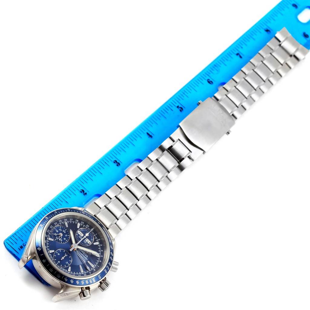The image shows an Omega Speedmaster 3222.80.00 Men
s Stainless Steel Blue Dial 3222.80.00 Men
s Stainless Steel Blue Dial watch laid flat with a metal bracelet next to a blue ruler.