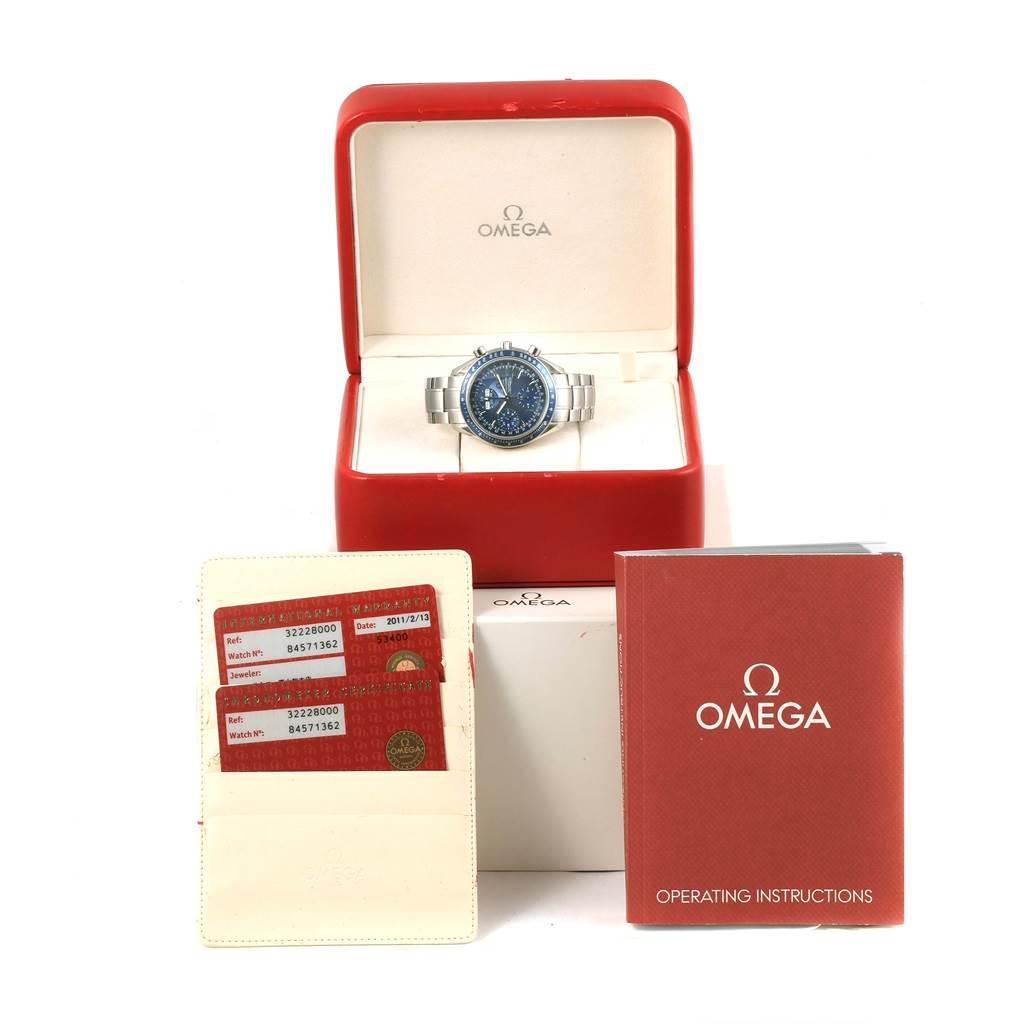 The image shows an Omega Speedmaster 3222.80.00 Men
s Stainless Steel Blue Dial 3222.80.00 Men
s Stainless Steel Blue Dial watch in its box along with instruction manuals and warranty cards.