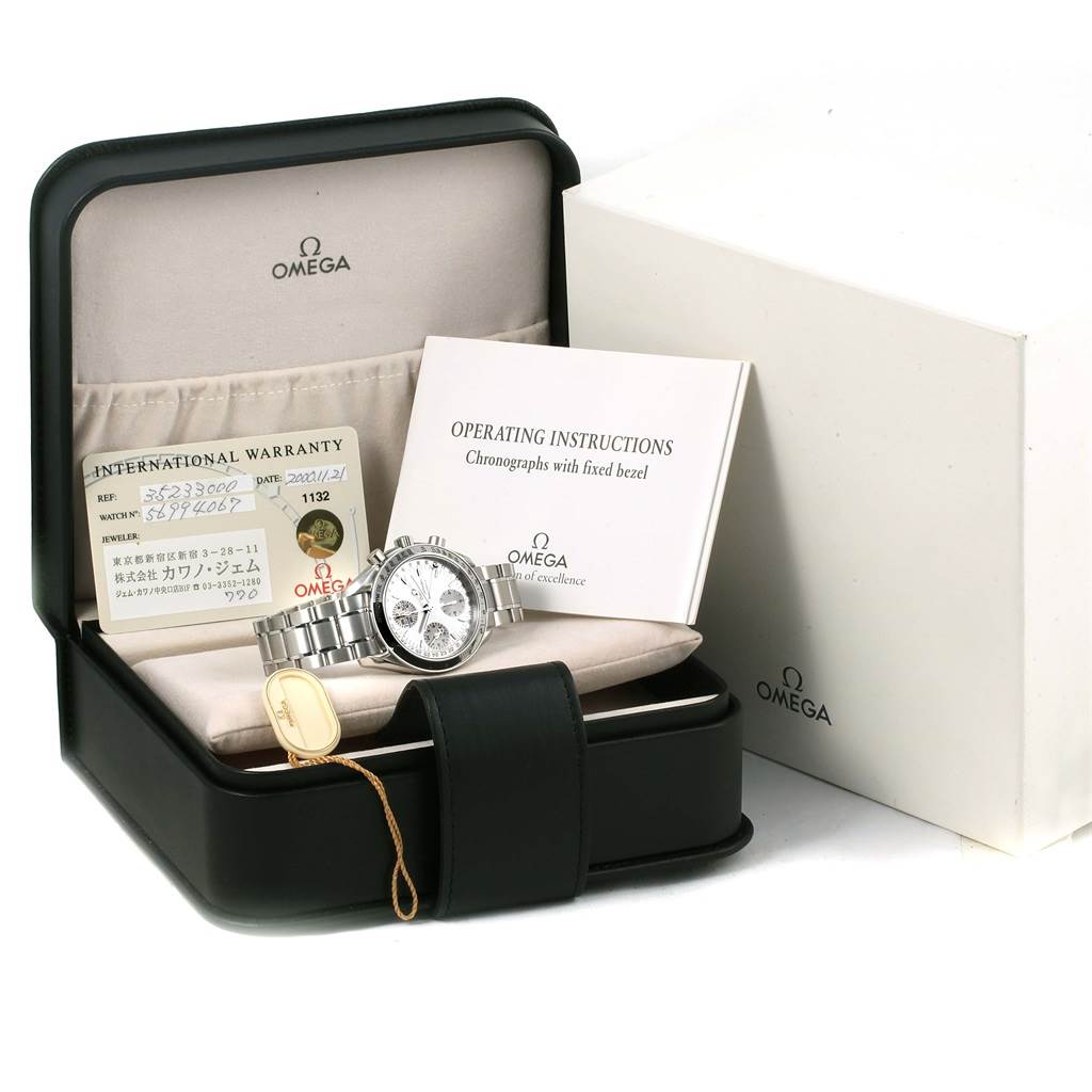 The image shows an Omega Speedmaster 3523.30.00 Men
s Stainless Steel Silver Dial 3523.30.00 Men
s Stainless Steel Silver Dial watch displayed in a case with an international warranty card and operating instructions.