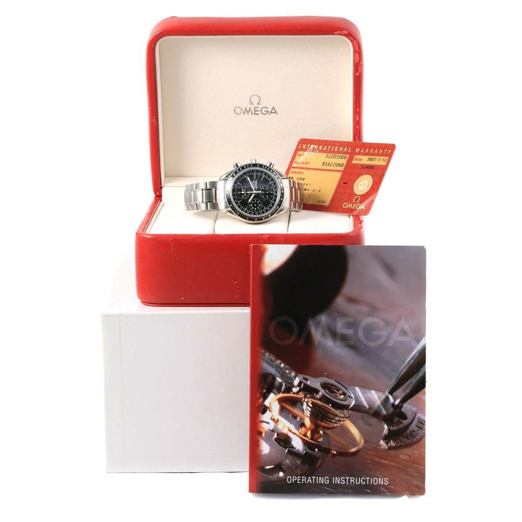 The image shows an Omega Speedmaster 3220.50.00 Men
s Stainless Steel Black Dial 3220.50.00 Men
s Stainless Steel Black Dial watch inside its red box, accompanied by the warranty card and operating instructions booklet.