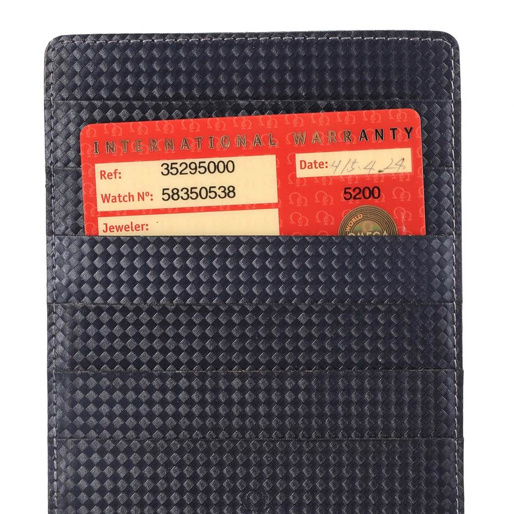 The image displays an International Warranty card for an Omega Speedmaster 3529.50.00 Men
s Stainless Steel Black Dial 3529.50.00 Men
s Stainless Steel Black Dial watch placed in a textured holder.