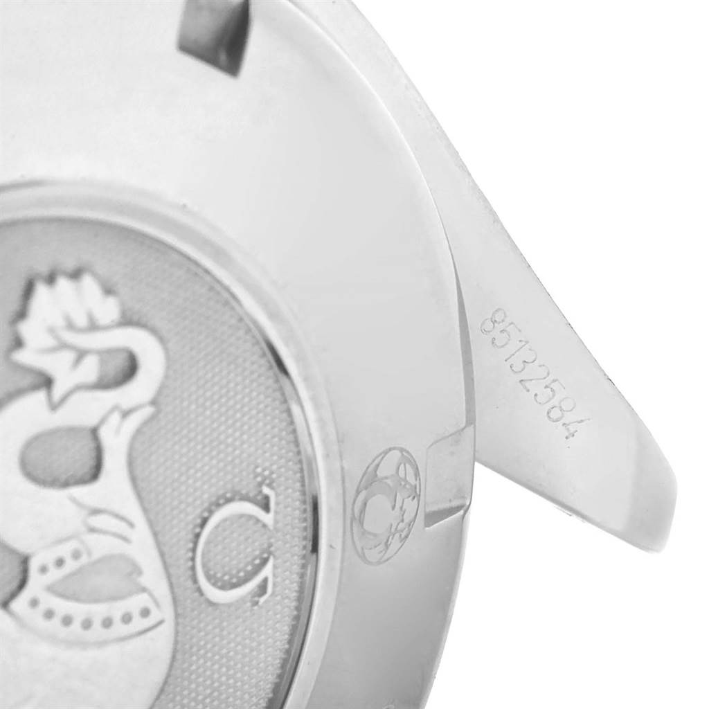 This image shows a close-up of the case back of an Omega Speedmaster 323.30.40.40.04.001 Men
s Stainless Steel White Dial 323.30.40.40.04.001 Men
s Stainless Steel White Dial watch, highlighting part of its logo and serial number.