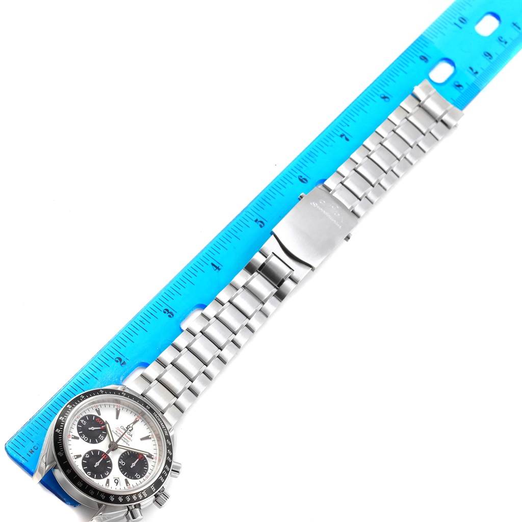 The image shows an Omega Speedmaster 323.30.40.40.04.001 Men
s Stainless Steel White Dial 323.30.40.40.04.001 Men
s Stainless Steel White Dial watch with its face, bracelet, and clasp, placed beside a blue ruler for scale.
