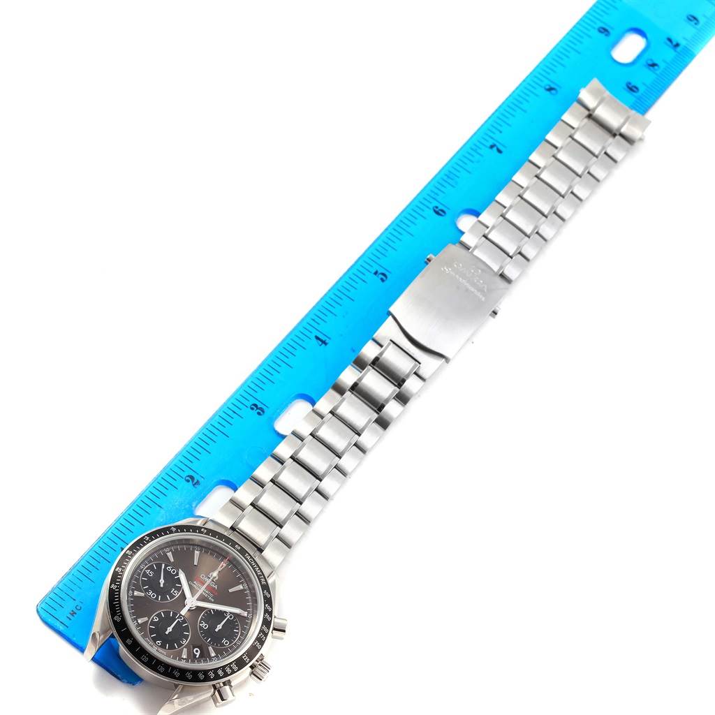 The image shows a top-down view of an Omega Speedmaster 323.30.40.40.06.001 Men
s Stainless Steel Grey Dial 323.30.40.40.06.001 Men
s Stainless Steel Grey Dial watch with a metal bracelet, measured against a blue ruler.