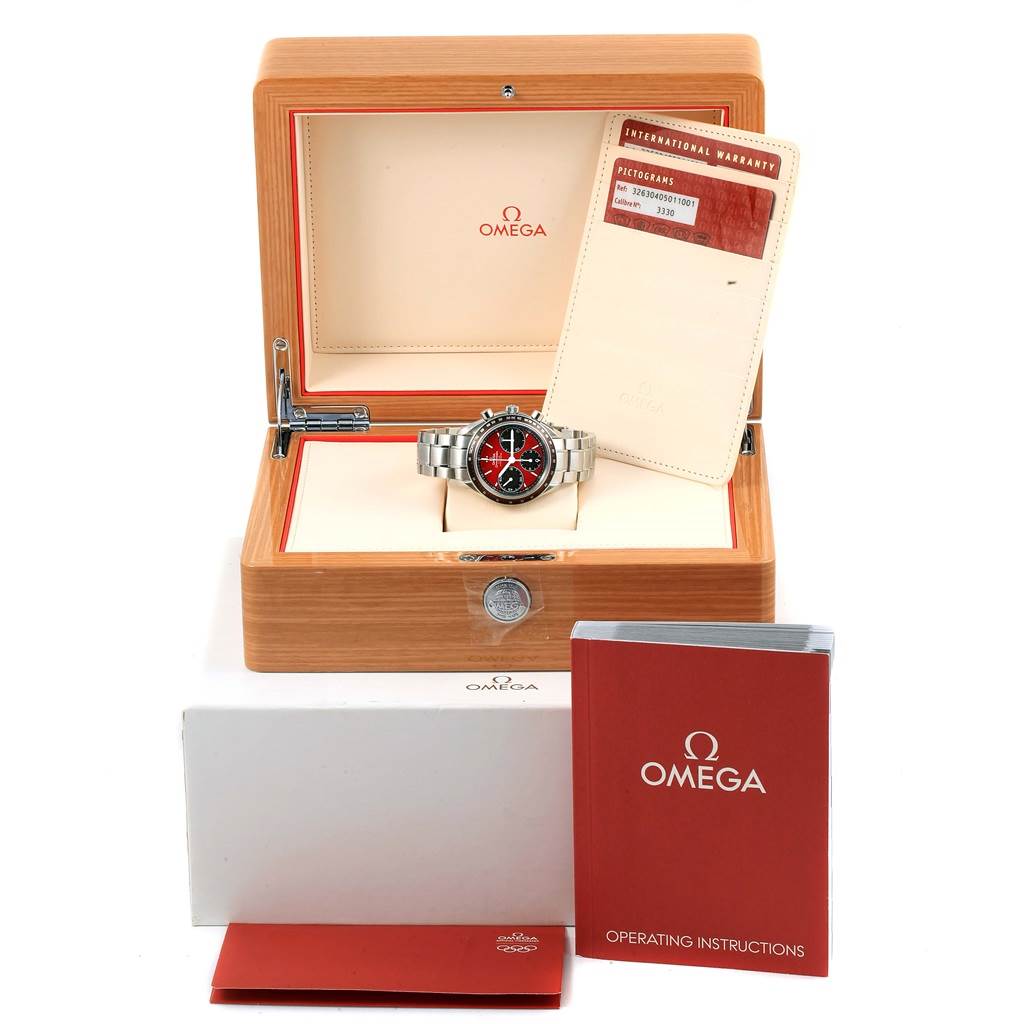 The image shows an Omega Speedmaster 326.30.40.50.11.001 Men
s Stainless Steel Red Dial 326.30.40.50.11.001 Men
s Stainless Steel Red Dial watch in a wooden box with warranty cards and an operating instructions booklet.