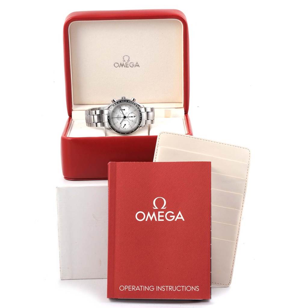 The image shows an Omega Speedmaster 326.30.40.50.02.001 Men
s Stainless Steel Silver Dial 326.30.40.50.02.001 Men
s Stainless Steel Silver Dial watch in its box, along with operating instructions and a leather case holder.