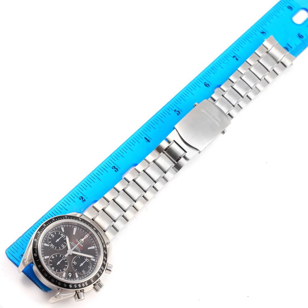 The Omega Speedmaster 323.30.40.40.06.001 Men's Stainless Steel Grey Dial 323.30.40.40.06.001 Men's Stainless Steel Grey Dial watch is displayed flat with its bracelet stretched out along a blue ruler.