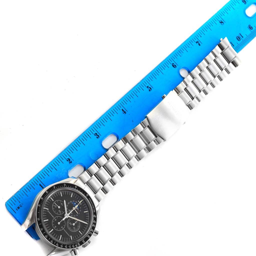 The Omega Speedmaster 3576.50.00 Men
s Stainless Steel Black Dial 3576.50.00 Men
s Stainless Steel Black Dial watch in the image is shown from above, displaying the face, bezel, and metal bracelet against a blue ruler.