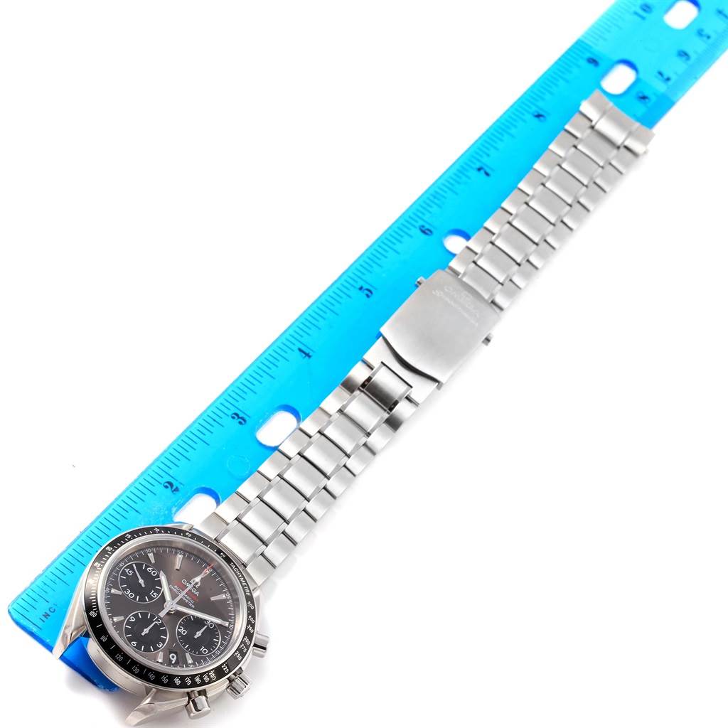 The image shows an Omega Speedmaster 323.30.40.40.06.001 Men
s Stainless Steel Grey Dial 323.30.40.40.06.001 Men
s Stainless Steel Grey Dial watch with its metal bracelet laid out beside a blue ruler for measurement.