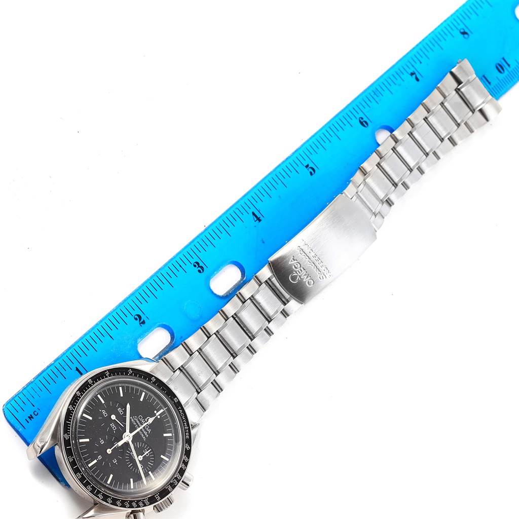 The Omega Speedmaster 3570.50.00 Men
s Stainless Steel Black Dial 3570.50.00 Men
s Stainless Steel Black Dial watch is shown from the top, with its face, bezel, and metal bracelet visible alongside a blue ruler for scale.