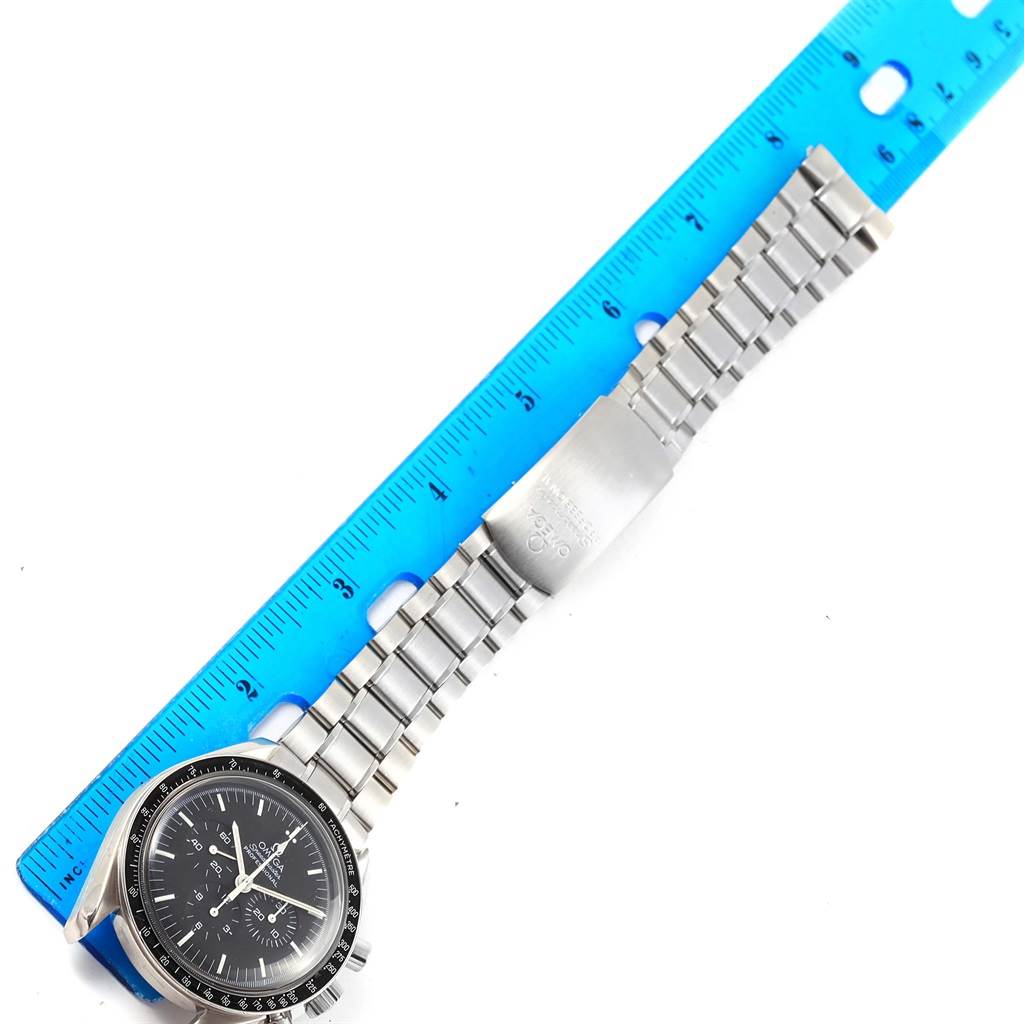 This image shows an Omega Speedmaster 3570.50.00 Men
s Stainless Steel Black Dial 3570.50.00 Men
s Stainless Steel Black Dial watch lying flat with a ruler measuring its stainless steel bracelet.