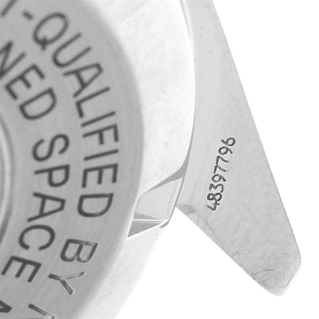 The image shows a close-up of the case back and a lug of the Omega Speedmaster 3570.50.00 Men
s Stainless Steel Black Dial 3570.50.00 Men
s Stainless Steel Black Dial watch, highlighting engraved text and serial number.