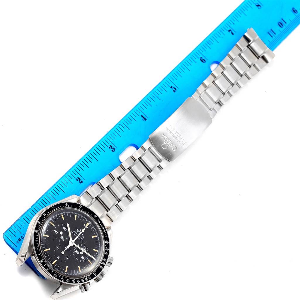 The Omega Speedmaster Men
s Stainless Steel Silver Dial Men
s Stainless Steel Silver Dial watch is shown flat, featuring the face, metal bracelet, and clasp alongside a blue ruler for size reference.