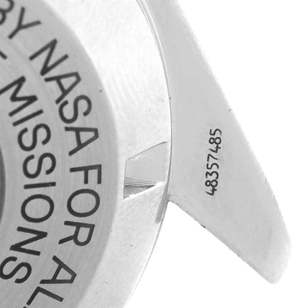 The image shows a close-up of the Omega Speedmaster Men
s Stainless Steel Silver Dial Men
s Stainless Steel Silver Dial
s case back and lug, featuring serial numbers and part of the engraved inscription.