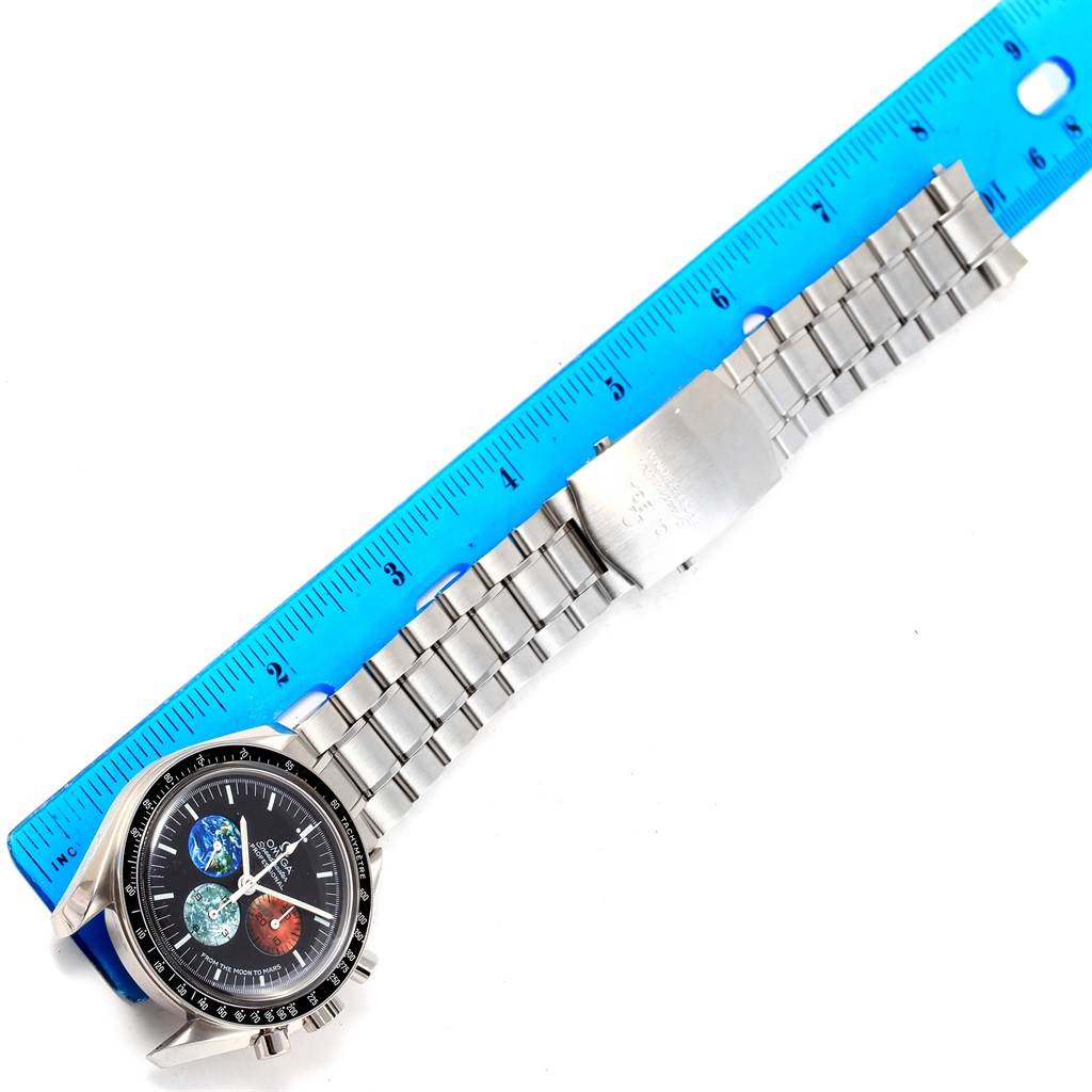 The Omega Speedmaster 3577.50.00 Men's Stainless Steel Black Dial 3577.50.00 Men's Stainless Steel Black Dial watch is shown laid flat with a ruler, displaying its face and metal bracelet.