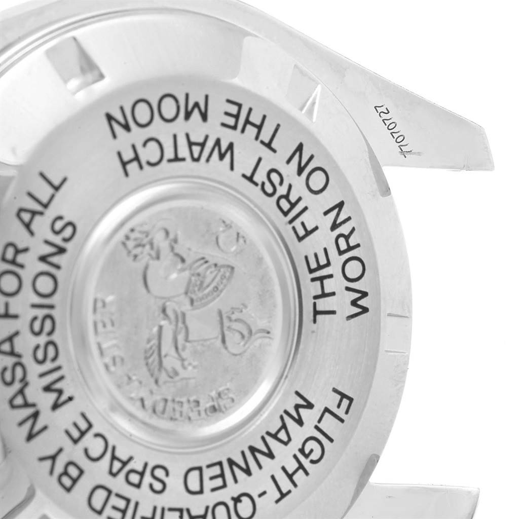 This image shows the back of an Omega Speedmaster 3575.20.00 Men's Stainless Steel White Dial 3575.20.00 Men's Stainless Steel White Dial watch case, featuring engraved text and an emblem.