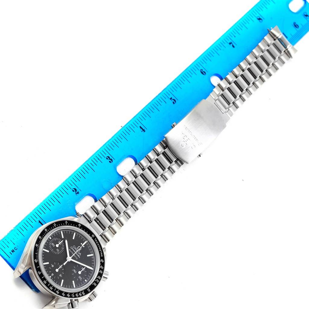 The image displays an Omega Speedmaster 3539.50.00 Men
s Stainless Steel Black Dial 3539.50.00 Men
s Stainless Steel Black Dial watch and its metal bracelet next to a blue ruler.